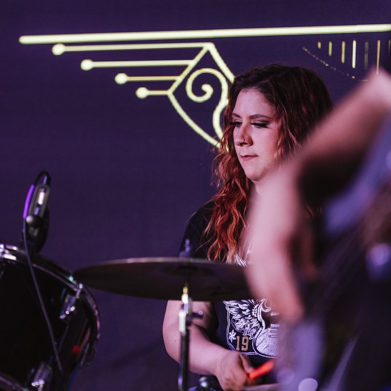 Drummer behind the kit with the band logo above